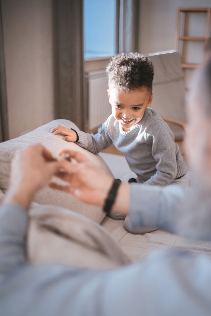 A happy child playing and interacting with family indoors, showcasing joy and connection.